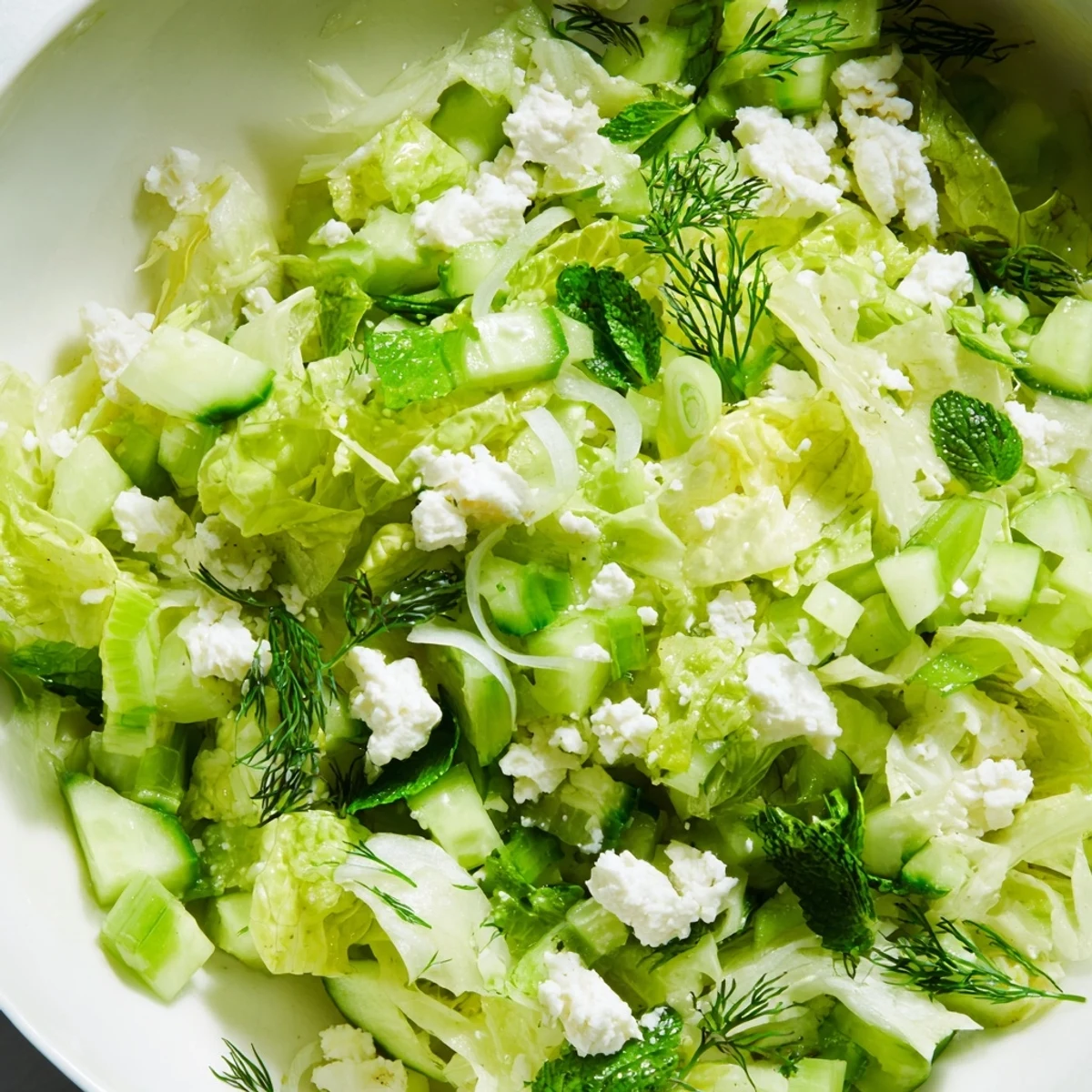 Vibrant maroulosalata featuring crisp lettuce, mint, dill, and scallions tossed in olive oil vinaigrette