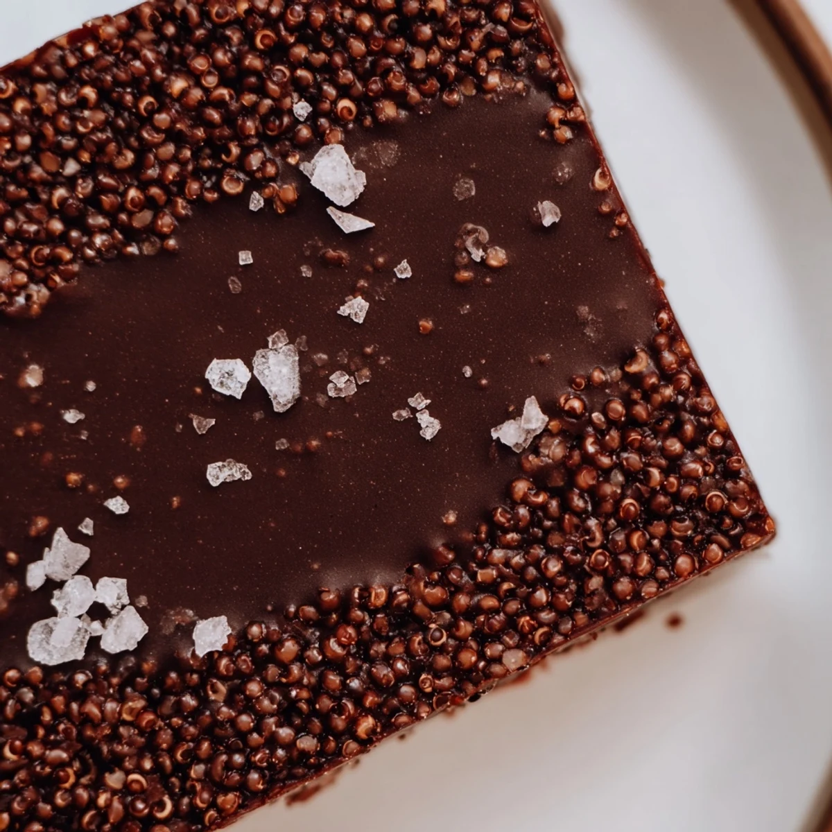 Gourmet dark chocolate quinoa crisps stacked on a rustic wooden board, highlighting their glossy finish and satisfying crunch factor