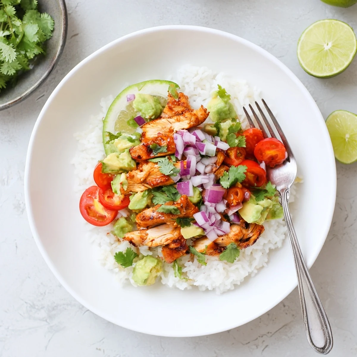 Honey lime chicken avocado rice stack layered in a glass bowl with fresh cilantro garnish