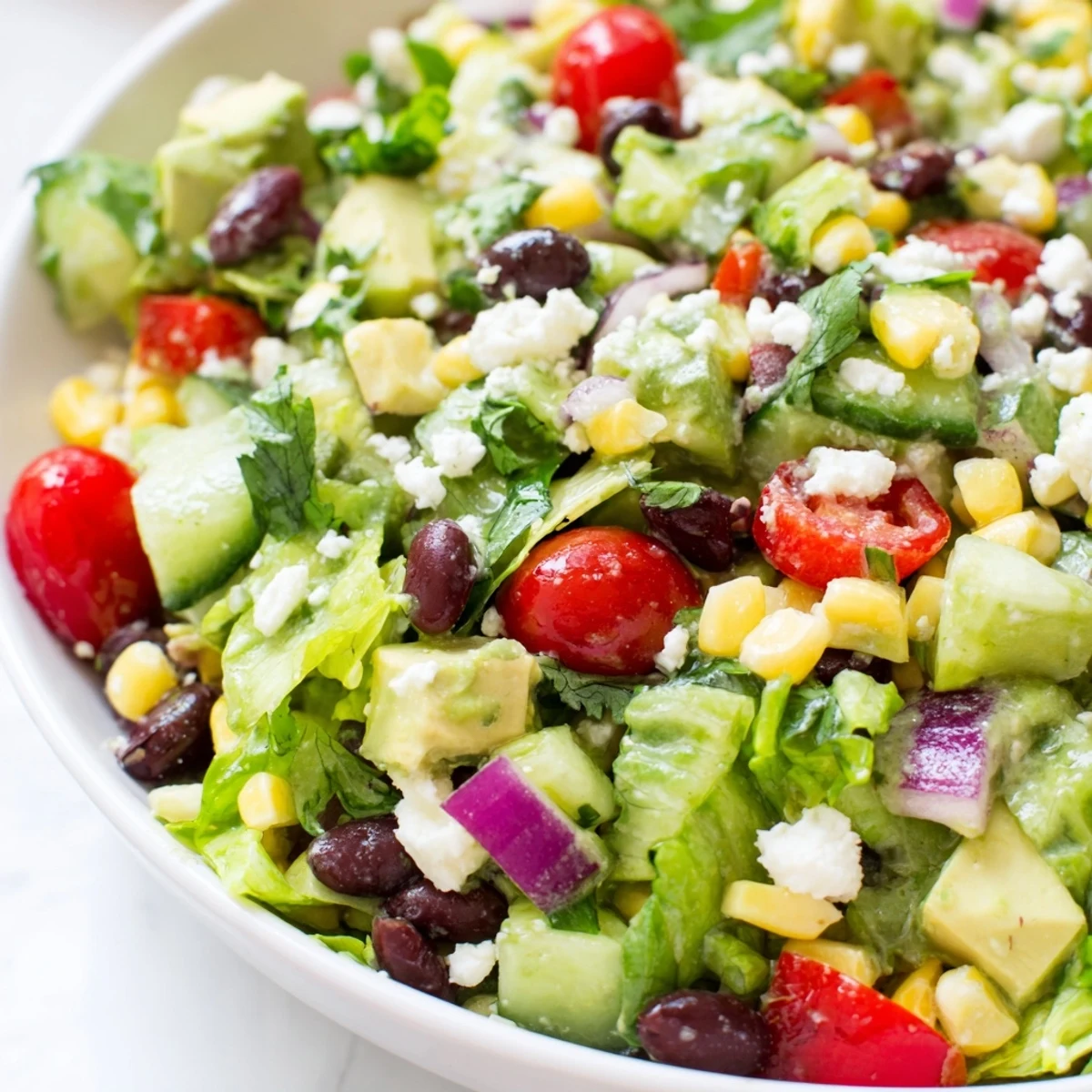 Mexican chopped salad topped with crumbled cotija cheese and drizzled with zesty lime dressing