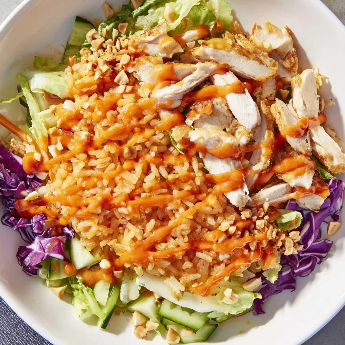 Creamy orange Bang Bang sauce drizzled over crisp vegetables and tender chicken with crunchy rice