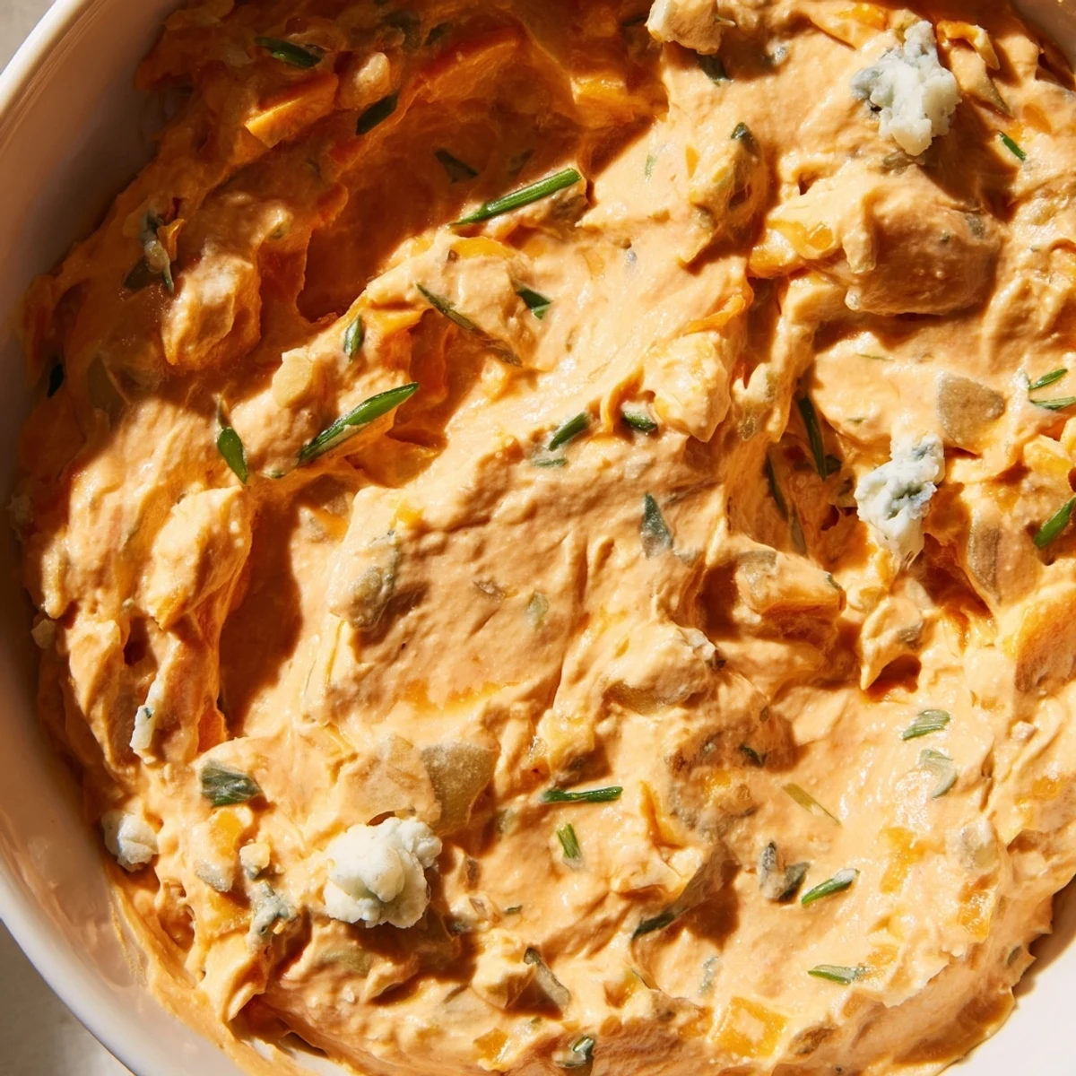 Creamy buffalo pickle dip served in a bowl with crunchy chips for game day snacking