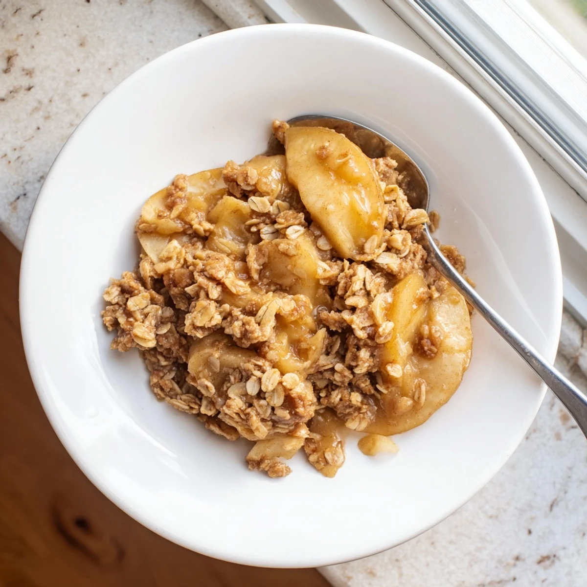 Warm Crockpot Apple Crisp topped with crunchy cinnamon oats and a scoop of vanilla ice cream
