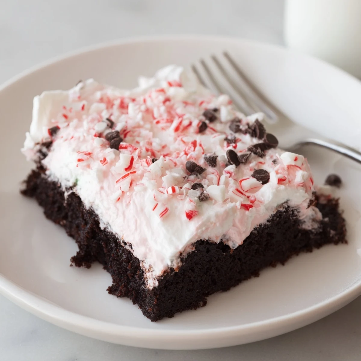 Sliced Peppermint Poke Cake chilled, minty pudding filling seeping into holes