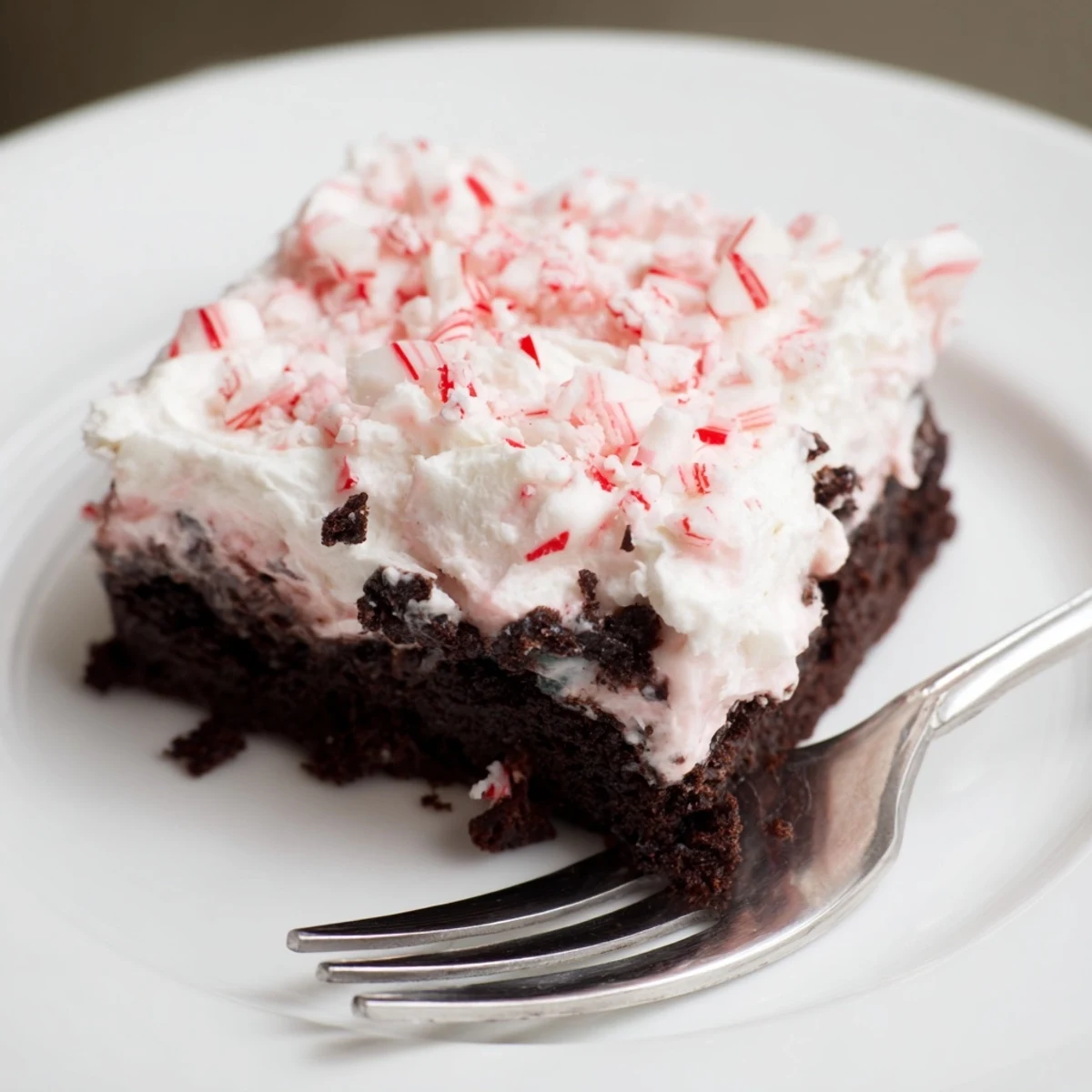 Easy Peppermint Poke Cake served on holiday platter, chocolate shavings sprinkled