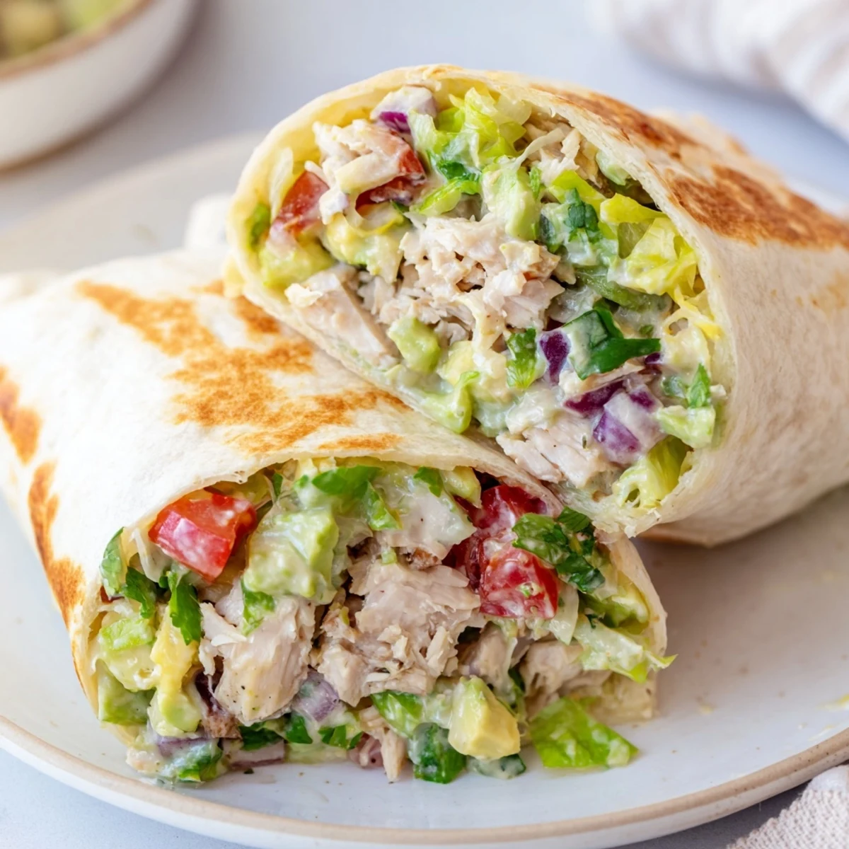 Chicken Avocado Ranch Burritos sliced on plate, golden toasted, creamy avocado visible