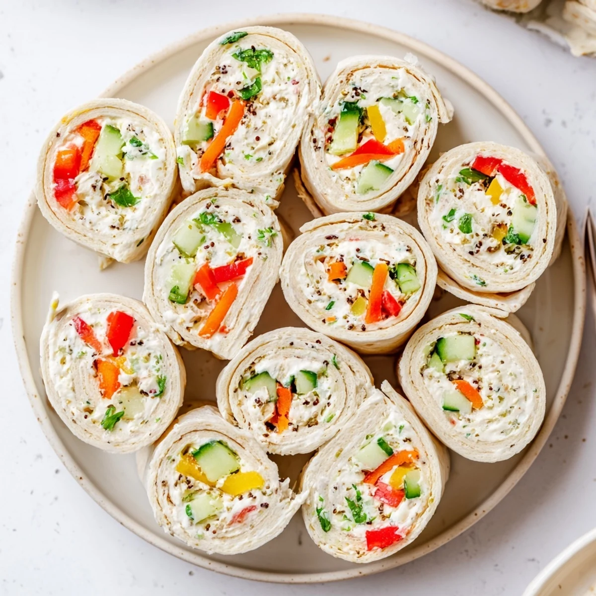 Vegetable Tortilla Roll Ups sliced on platter, creamy filling and crunchy vegetables