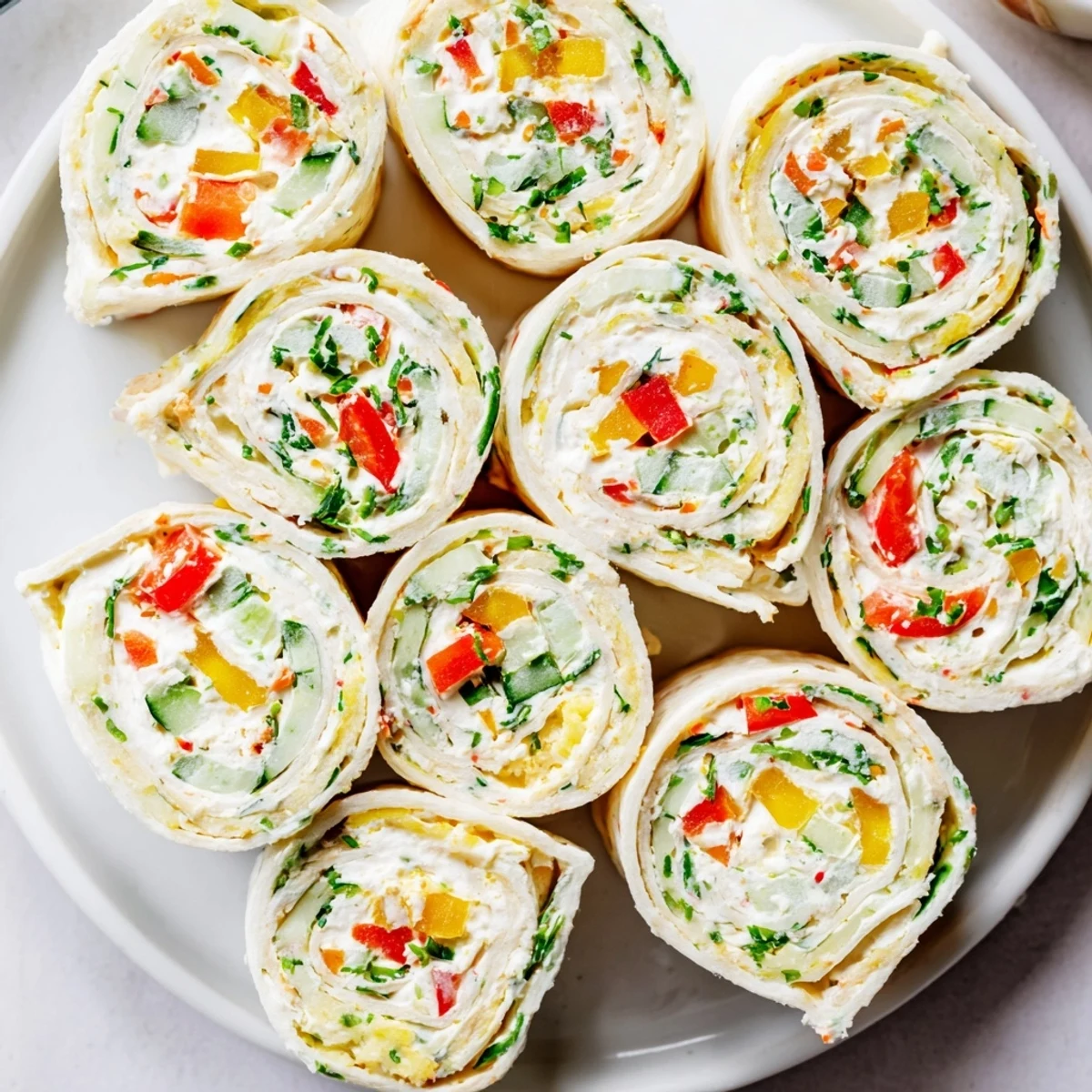 Handheld Vegetable Tortilla Roll Ups arranged with dipping sauce, tangy and fresh