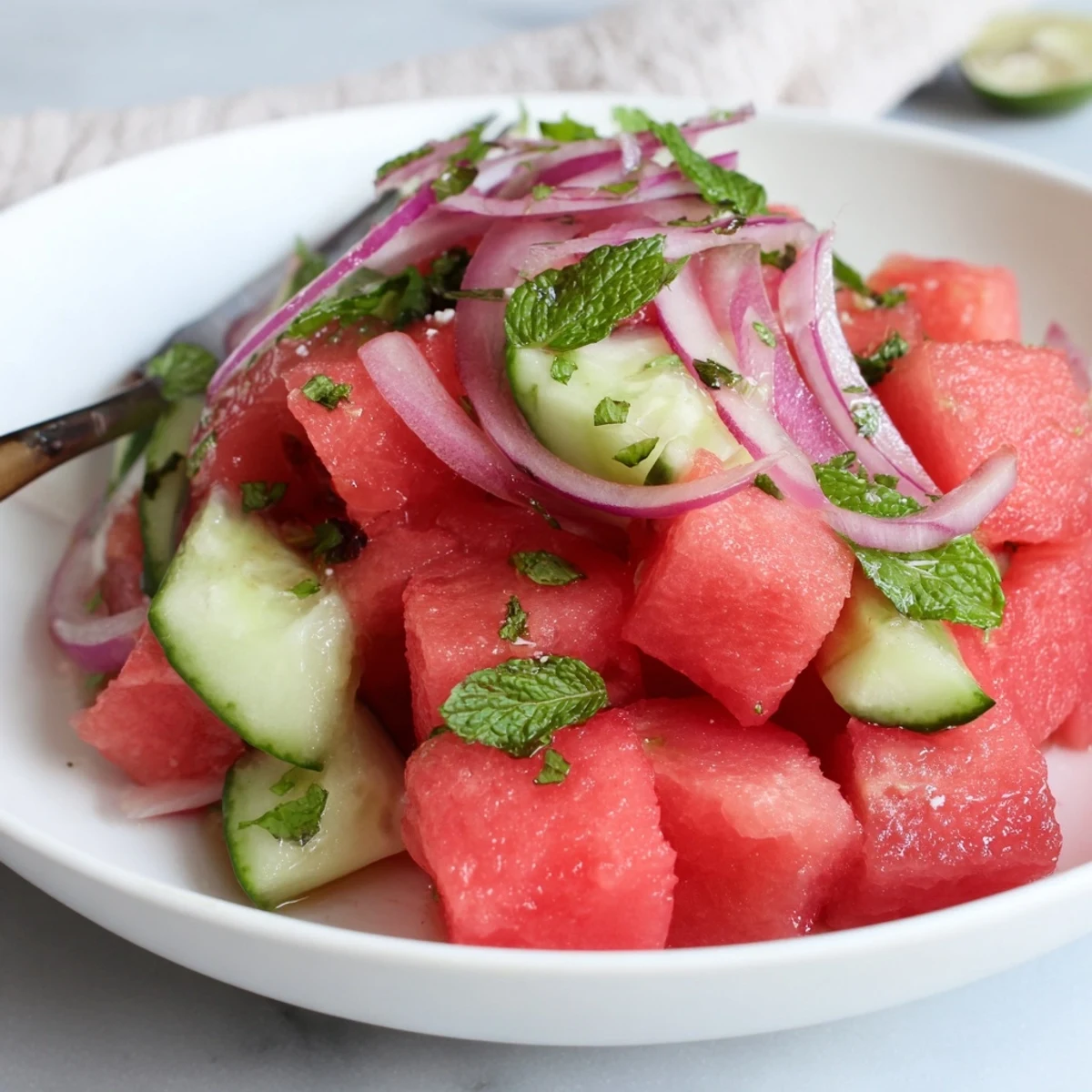 Watermelon Cucumber Salad with mint and lime, juicy cubes glistening, perfect for picnics