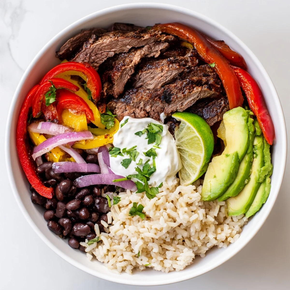 Layered over brown rice, Steak Fajita Power Bowls feature creamy avocado slices.