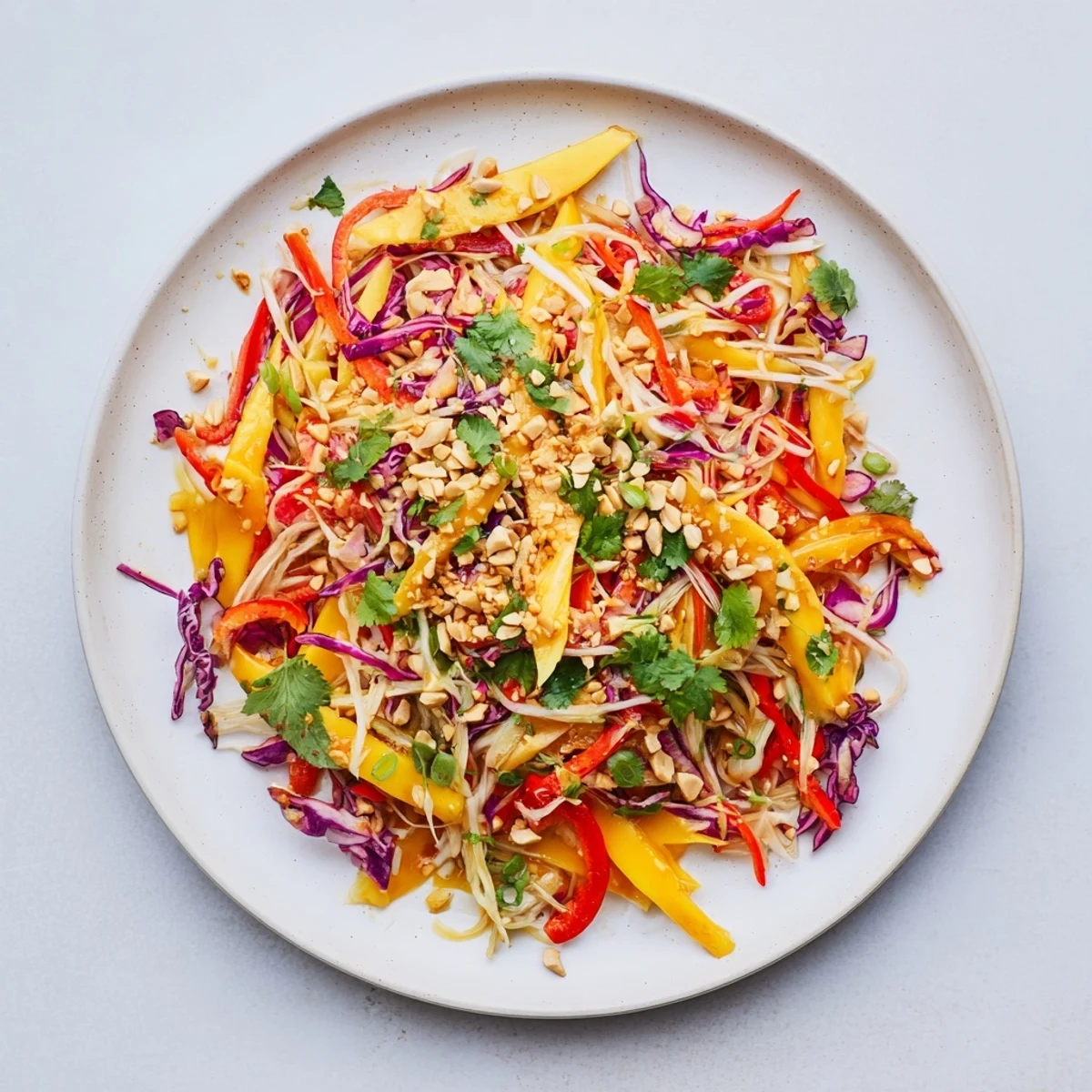 Vibrant tropical mango slaw featuring julienned vegetables, fresh cilantro, and tangy lime dressing on a wooden board