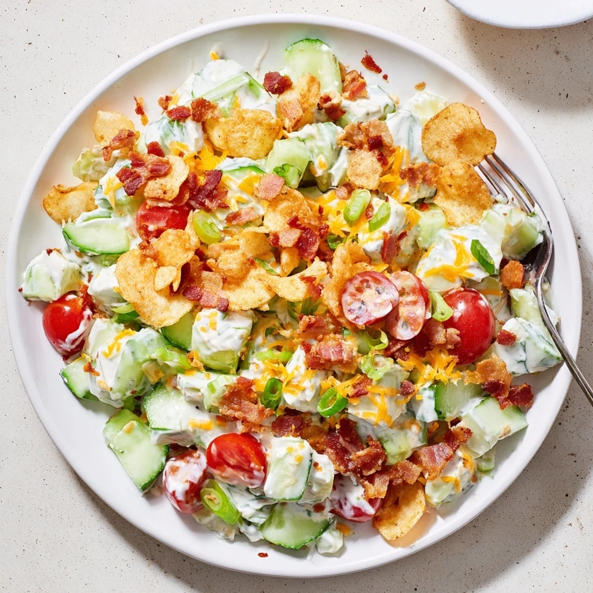 Fresh cucumber ranch crack salad topped with crunchy potato chips and savory ranch dressing