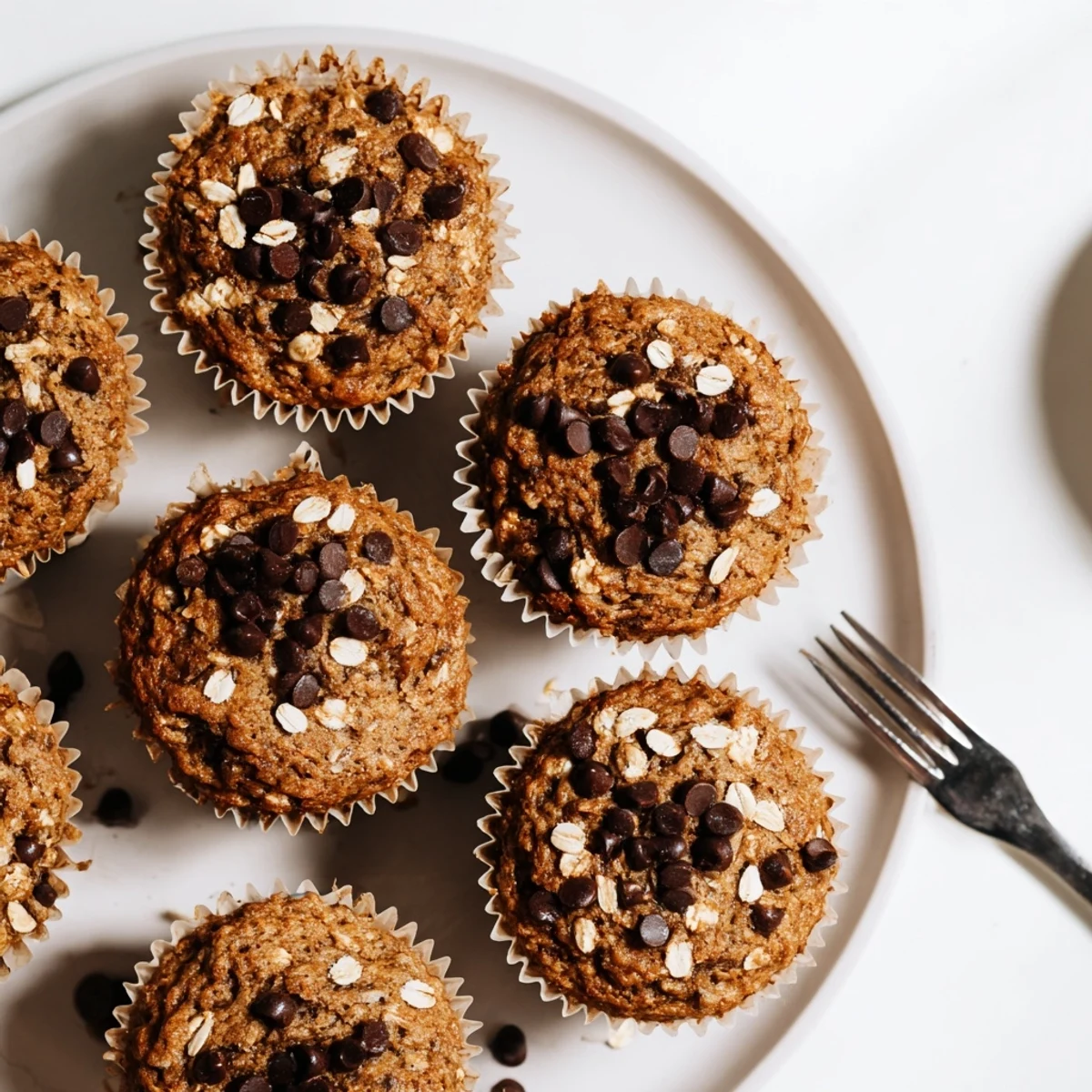 Soft moist banana chocolate chip muffins topped with melty chocolate chips and hearty oats