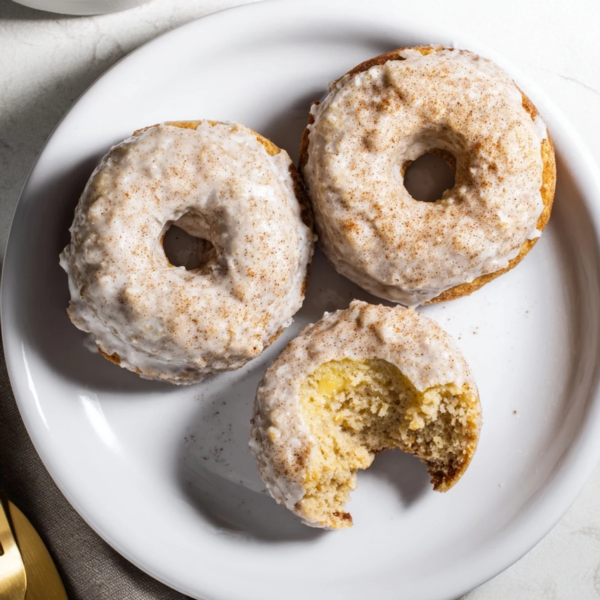 Breakfast Banana Donuts with powdered glaze, moist banana bites and warm spices.