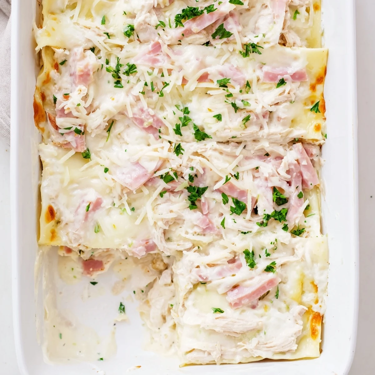 Sliced Chicken Cordon Bleu Lasagna revealing tender chicken, ham, and creamy béchamel sauce
