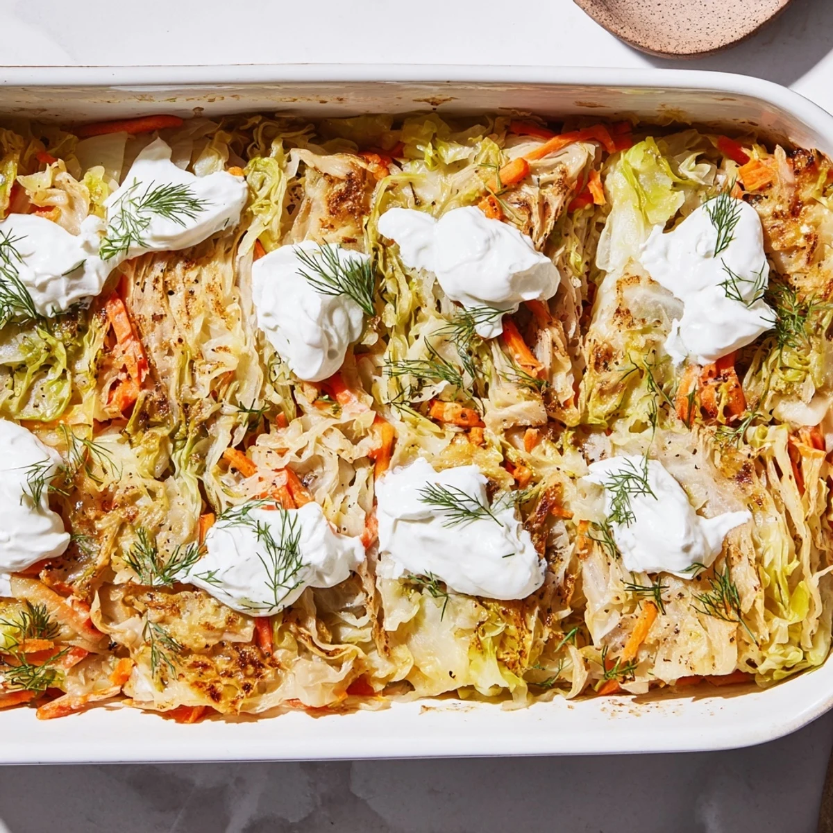 Comforting vegetarian slow roasted cabbage and sauerkraut casserole served warm with a garnish of green herbs