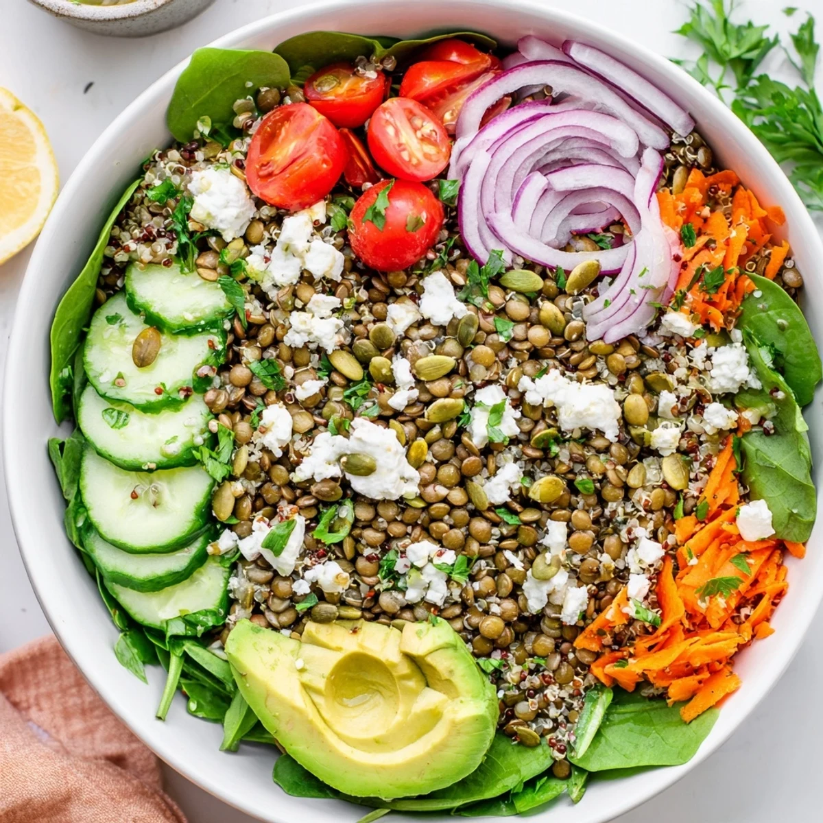 Colorful lentil grain bowl topped with fresh veggies and zesty herbed dressing