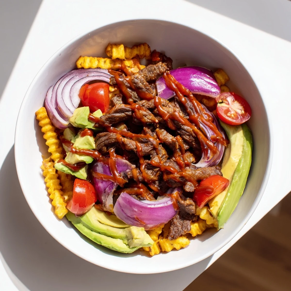 Steak strips crispy fries bowl recipe featuring golden fries topped with juicy seared steak and fresh avocado slices.
