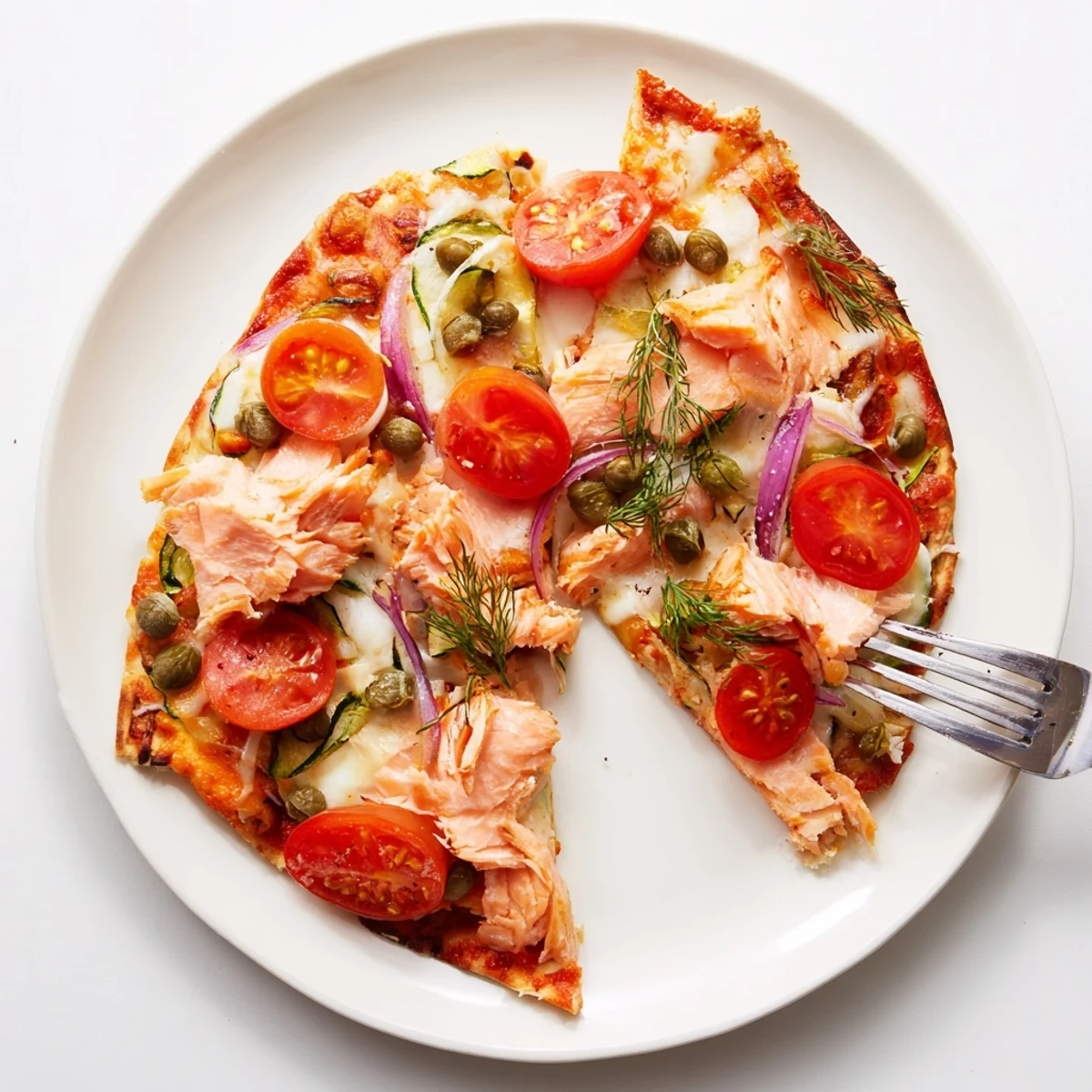 Easy leftover salmon tortilla pizza with creamy base, crispy crust, and a sprinkle of fresh herbs.